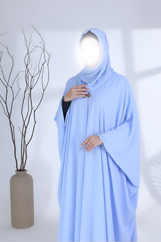 Woman wearing a sky blue abaya by Clarity Glam with loose, flowing fabric and matching hijab